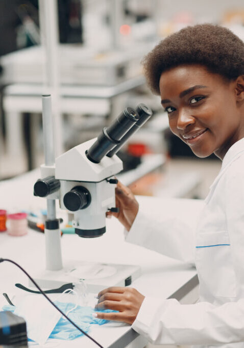 Scientist african american woman working in laboratory with electronic tech instruments and microscope. Research and development of electronic devices by color black woman.