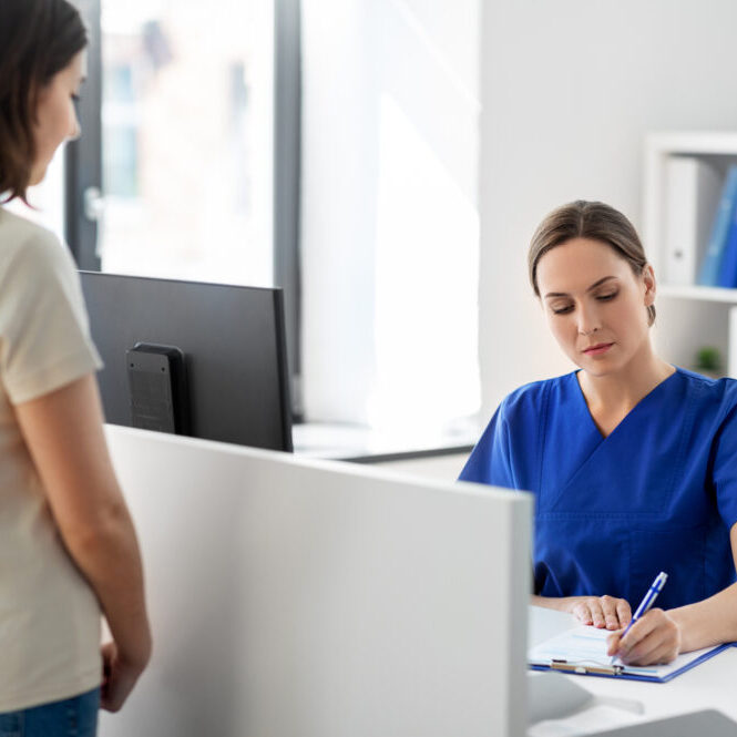 medicine, people and healthcare concept - female doctor or nurse with clipboard and patient at hospital